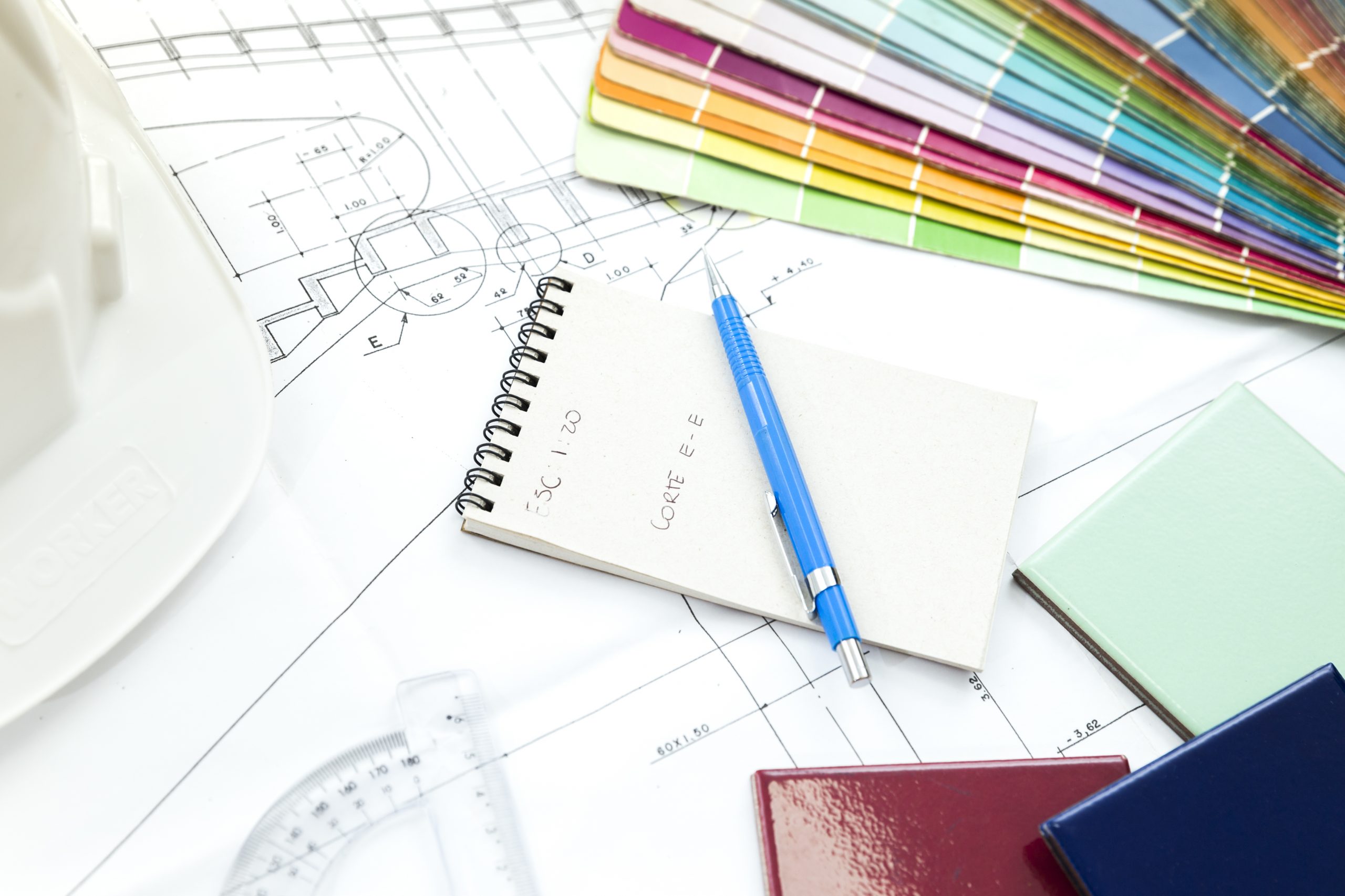 facade-panels-near-pen-notebook-table A blueprint with building supplies and color swatches