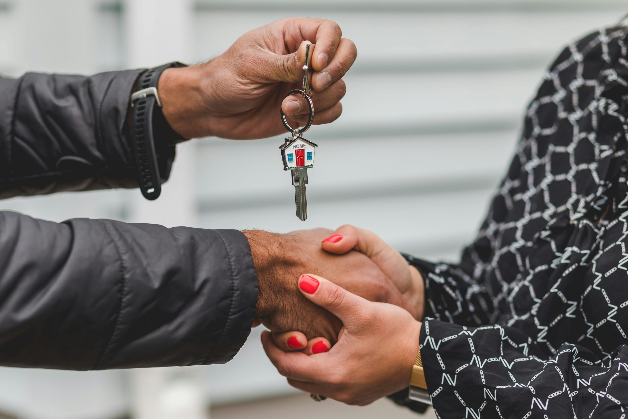 pexels-rdne-8293778 Two people shaking hands; one is handing over house keys